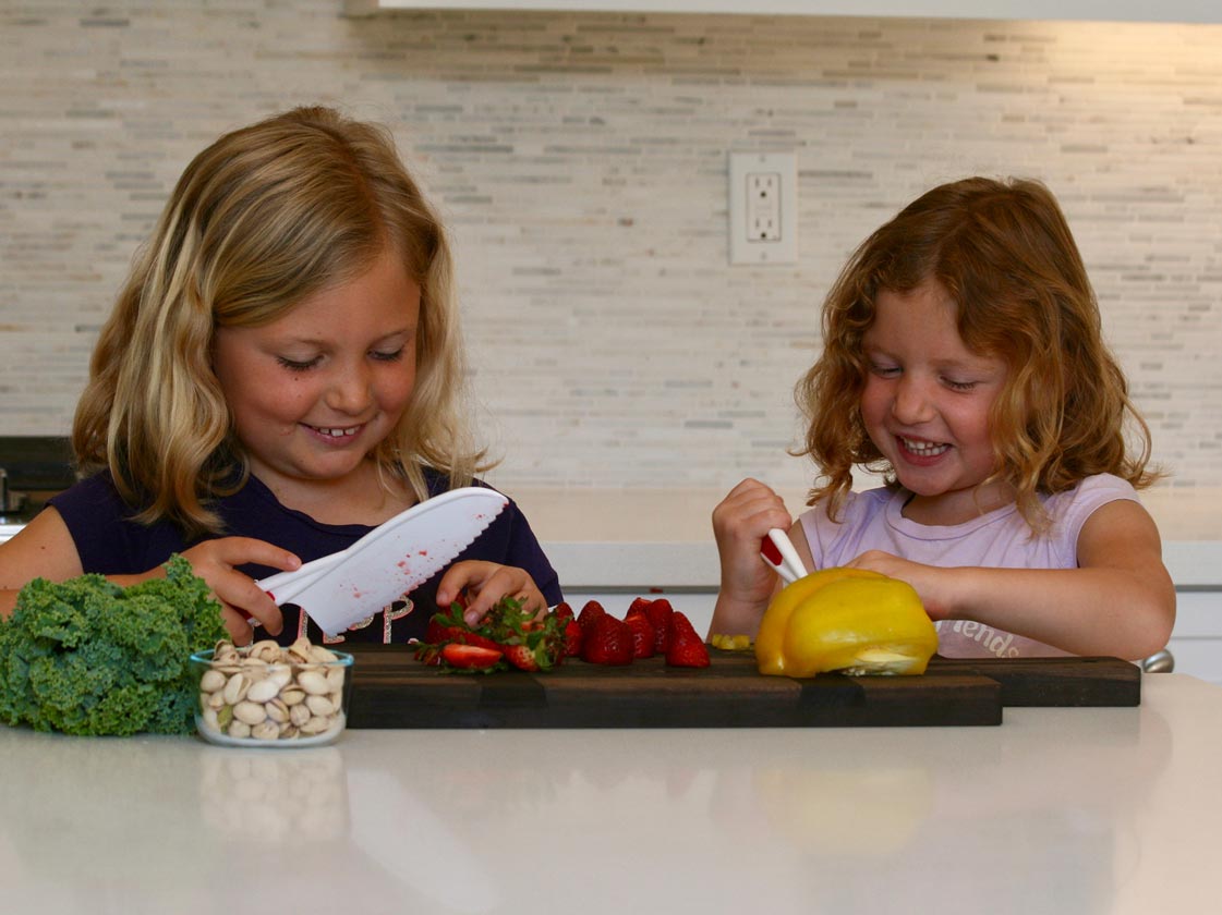 Kids chopping fruits and veggies in the kitchen