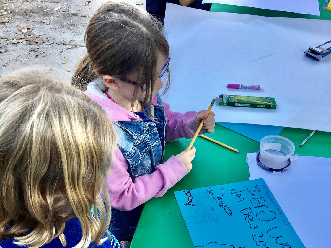 Kids making a sign in favor of zero-waste lunch day at school.